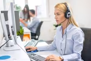 Bilde av en kvinnelig ansatt som tar i mot telefonsamtaler